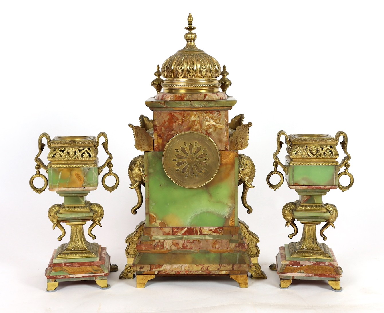 A late 19th century French ormolu mounted marble and green onyx clock garniture, of Indian inspiration, clock 34cm wide, 63cm high, side vases 36cm high